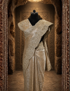 Full back profile of the draped golden saree look, highlighting its fluid pleats, rich metallic texture, and sophisticated pallu fall.