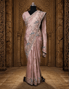 Full-length front view of a model showcasing a shimmering lavender tissue saree with intricate floral zari borders under a crystal chandelier.