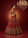 Back view of the full red bridal lehenga highlighting the deep U-cut blouse design and the expansive, heavily embroidered silk skirt.