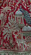 Close-up of heritage architecture and floral embroidery on a ₹84,500 Red Silk Lehenga.