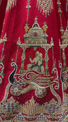 Detailed view of blue and red Kardana beadwork on a traditional red silk wedding lehenga.
