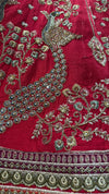 Detailed view of the red bridal lehenga border featuring intricate floral thread work and cut bead embellishments.