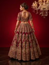 Elegant back profile of the red bridal lehenga highlighting the expansive silk flare and the detailed craftsmanship of the blouse.