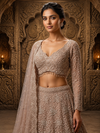 Full-length front view of a model styling a voluminous mauve net lehenga covered in vertical geometric lines of silver sequence and beads.