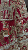 Hand-embroidered doli motif on a cherry red silk lehenga featuring intricate bead and thread work.
