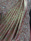 A detailed view of the saree pleats showing the subtle dual-tone pink and antique gold shimmer inherent to the premium tissue weave.