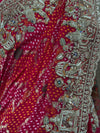 A detailed shot focusing on the fluid body of the Georgette saree, displaying the contrast between the traditional tie-dyed Bandhani dots and the heavily encrusted floral zari border.