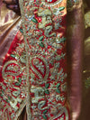 A macro perspective focusing on the saree's border panels, revealing the layered handiwork of gold sequins, stones, and beautifully defined metallic elephant outlines on a crimson-orange base.