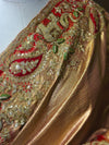 A close-up studio detail shot of the Tissue fabric's unique herringbone texture weave, displaying the fine craftsmanship of the zari and green thread work.