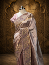 A side-angle studio presentation under soft overhead lighting emphasizing the brilliant, liquid-like metallic drape of the mauve tissue silk over the shoulder.