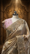 A close-up portrait view focusing on the upper bodice of the mannequin, showcasing the contrasting pastel pink blouse embellished with small pearl details alongside the heavy peacock border resting over the shoulder.
