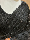A macro perspective close-up showing the extreme detail of the handwork, revealing clusters of black cut beads structured into starburst motifs alongside tiny glittering sequins on the black net mesh.