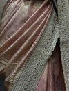 A close-up perspective focusing on the structured folds of the draped tissue silk, emphasizing the fabric's liquid-like sheen contrasting against the embroidered border edge.