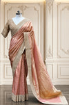 A grand full-length view of the peach tissue silk saree draped gracefully on a mannequin, showcasing its premium golden-metallic sheen and detailed scalloped pallu against a classic cream interior wall with elegant moldings.