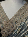 A macro photograph of the scalloped border, detailing rows of clear crystals, tiny metallic sequins, micro cut beads, and white pearls tightly stitched into scrolling floral lace patterns.