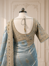 A portrait view from the front showcasing the elegant fall of the pallu across the shoulder, contrasting beautifully with the dense, intricate zari sleeve work of the blouse.