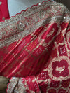 A close-up view of the saree's shoulder pleats, showcasing the intricate golden peacock motifs printed on the Rani pink fabric alongside the heavily encrusted sequin and pearl border.