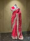 Full-length front shot showcasing the fluid drape of the Rani pink saree on a mannequin, highlighting the contrast between the printed skirt and the heavily worked shoulder pallu.
