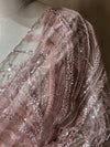 Detailed shot of the shoulder drape, highlighting the textured contrast between the sheer mesh fabric and the heavy glistening thread and bead work.
