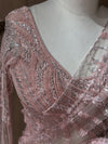 Close-up detail shot of the V-neckline and sleeve cap, showing dense cutdana and sequin embroidery arranged in geometric and floral patterns.
