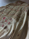 Macro photograph capturing the layered crescent pattern of the scalloped lace, detailing clear crystals, beads, and fine golden embroidery.