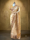 Full-length display of a champagne gold tissue silk saree on a mannequin, showcasing its metallic luster, delicate body bootis, and elaborate scalloped borders.