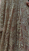 Macro shot of the pastel peach net fabric highlighting the intricate hand-stitched silver cut beads and transparent sequins.