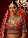 Red lehenga choli in pure silk featuring heavy manual Zarkan and white pulse pearl embroidery.