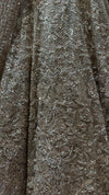 Close-up macro shot of the beige net fabric highlighting the intricate layout of silver and champagne-toned kardana cut beads and sparkling crystals.