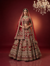 Full-length shot of a luxury cherry red silk lehenga showcasing the heavy bottom border and heritage storytelling motifs.