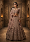 Full-length front view of a model in a voluminous lavender net lehenga with vertical cut bead embroidery under a crystal chandelier.