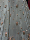 Detailed profile of the lehenga skirt's panel design, showing the wave-like layouts of glittering silver sequins and delicate floral thread art.