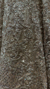 Detailed profile of the lehenga skirt's panel design, showing the wave-like patterns of high-shine sequence work and delicate jarkan embellishments.