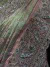 Close-up macro shot of the saree's border detailing intricate paisley and floral motifs rendered in pink resham threads, bright silver sequences, and golden zari.
