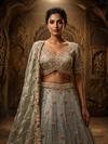 Portrait shot of the model showcasing the matching sky blue choli with a wide sweetheart neckline framed in dense hand-cut bead and pearl borders.